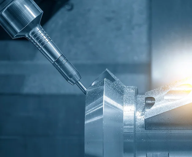 Usinage CNC : une fraiseuse sculpte une pièce métallique angulaire, créant des copeaux brillants.