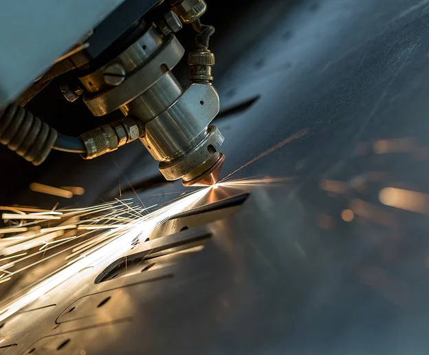 Découpe laser de métal, produisant des étincelles brillantes et des résidus de coupe.